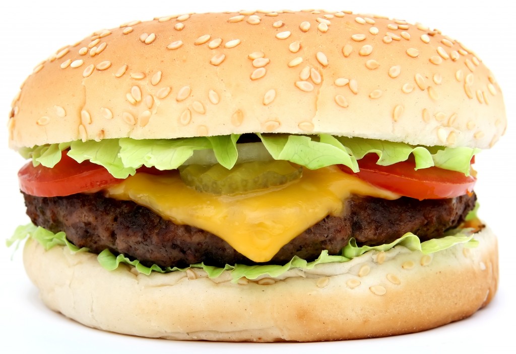 Cheese burger with lettuce cheese and tomato, isolated over white, macro, close up with copy space